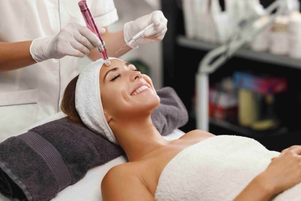 Close up of a lovely caucasian woman smiling face having microdermabrasion non invasive therapy with derma pen in a wellness center | Parlour at the Village Medspa in Salado, TX