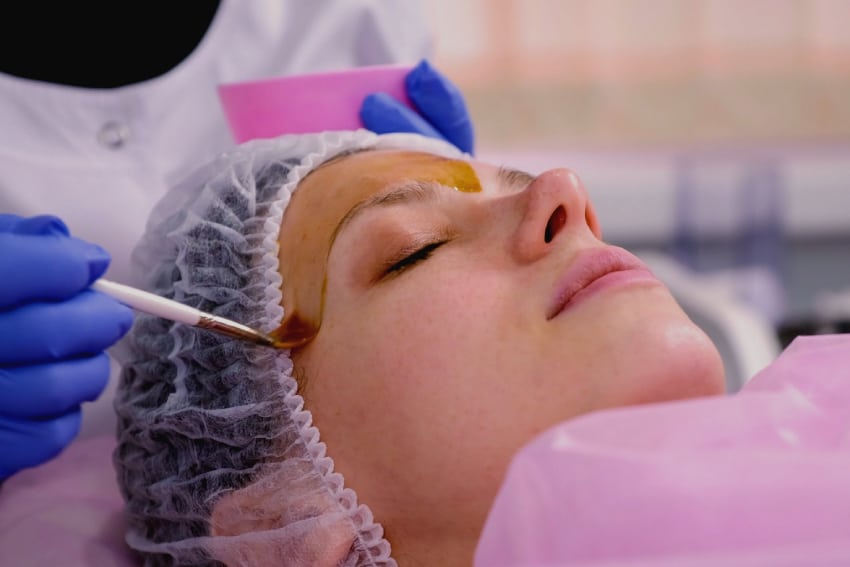 Lying Woman Getting Aqua gold facial on Her Face | Parlour at the Village in Salado, TX