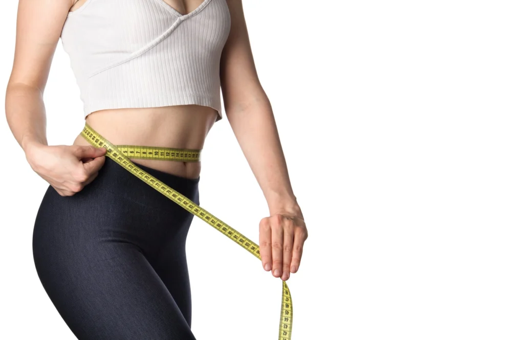 A Female checking her waist size after Weight Loss treatment in Salado, TX, at Parlour at the Village
